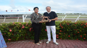 La periodista Natacha Batista, editora deportiva de Telecentro Canal 13 de televisi&oacute;n, premia este s&aacute;bado (25-5-2024) al Dr. &Aacute;ngel Contreras, propietario del Establo San Antonio y de la yegua Primera Dama (1), ganadora del Cl&aacute;sico D&iacute;a de las Madres, en el Hip&oacute;dromo Quinto Centenario.